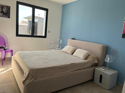 une chambre avec un lit et une fenêtre dans l'établissement La Maison Laurier, à Lézignan-Corbières