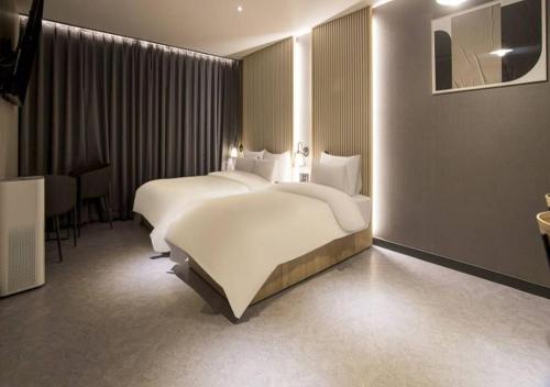 a hotel room with two beds and a table at Day & Night Hotel in Incheon
