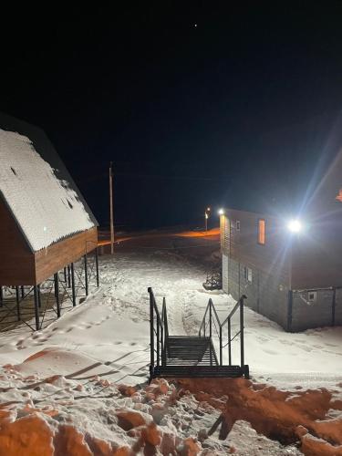 a chair sitting in the snow at night at Chalet Gudauri in Gudauri