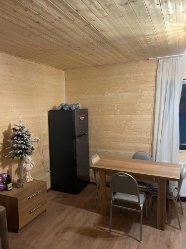 a dining room with a table and a black refrigerator at Chalet Gudauri in Gudauri