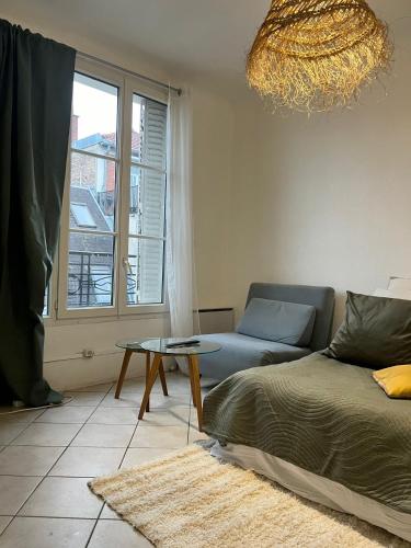 un salon avec un canapé et une table dans l'établissement Élégant cocon lumineux au cœur de Paris, à Paris