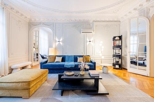 un salon avec un canapé bleu et une table basse dans l'établissement Amazing Apartment 4Bedrooms Champs Elysées AC, à Paris