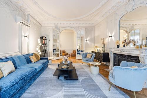 un salon avec un canapé bleu et une cheminée dans l'établissement Amazing Apartment 4Bedrooms Champs Elysées AC, à Paris