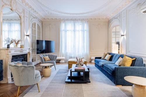 un salon avec un canapé bleu et une télévision dans l'établissement Amazing Apartment 4Bedrooms Champs Elysées AC, à Paris