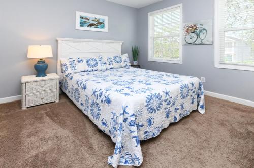 um quarto com uma cama azul e branca e uma janela em A Dream em Myrtle Beach