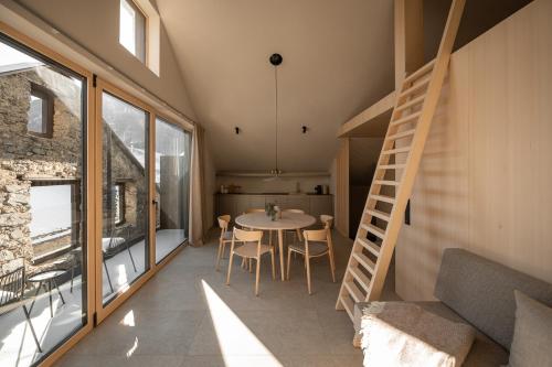 a room with a table and chairs and a staircase at Calva B&B Apartments in Malles Venosta