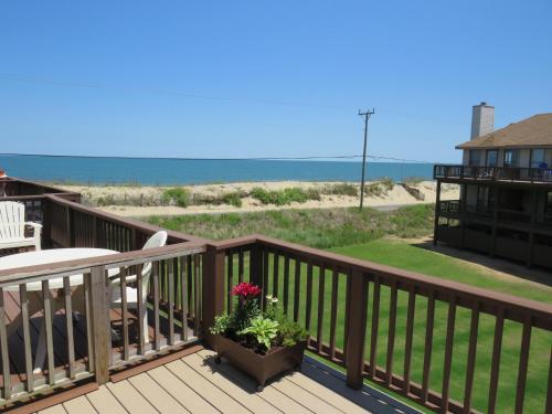 a deck with a potted plant and the ocean at Escape OBX in Kitty Hawk