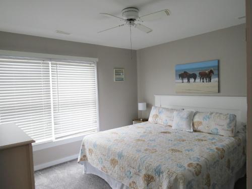 a bedroom with a bed and a painting of horses at Escape OBX in Kitty Hawk