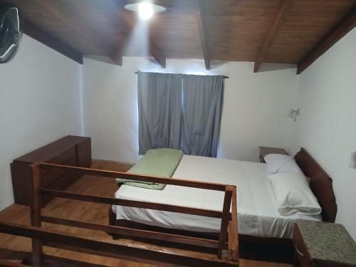 un dormitorio con una cama y una ventana en Los jilgeros, en Santa Rosa de Calamuchita