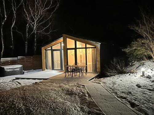 a cabin with a table and chairs in the snow at Tiny House Útulno in Trojanovice