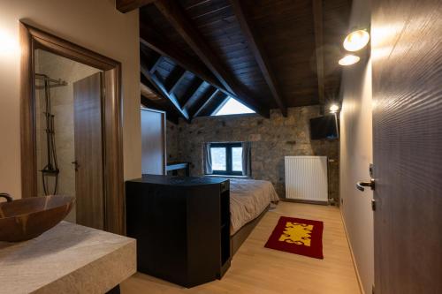 a bedroom with a bed and a bathroom with a sink at Eptalofos Mountain Resorts in Eptalofos