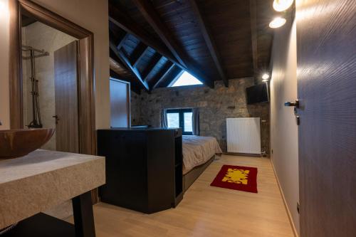 a bedroom with a bed and a red rug at Eptalofos Mountain Resorts in Eptalofos