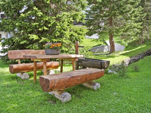 a picnic table and bench with a plant on it at Apartment Residenza Chesa Margun 15-4 by Interhome in Surlej