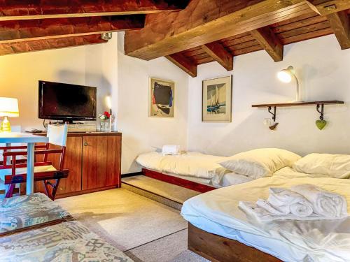 a room with two beds and a desk and a tv at Apartment Residenza Chesa Margun 15-4 by Interhome in Surlej