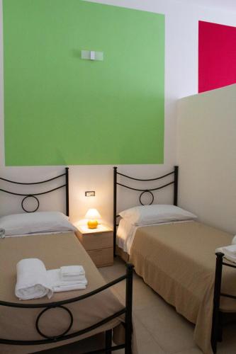 two beds in a room with a green and red wall at Louis House ad Agerola per Amalfi Positano Pompei in Agerola