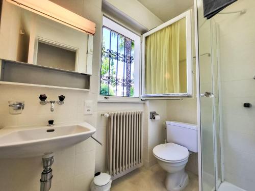 a bathroom with a sink and a toilet and a window at Holiday Home Villetta Isabella by Interhome in Ascona