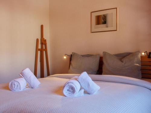 a bedroom with a white bed with towels on it at Apartment Dahlia by Interhome in Champoussin