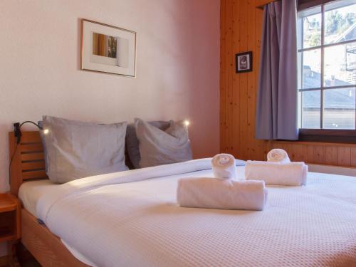 a bedroom with a bed with two towels on it at Apartment Dahlia by Interhome in Champoussin