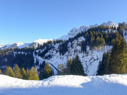 a view of a snowy mountain with trees on it at Apartment Dahlia by Interhome in Champoussin