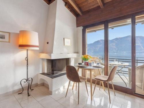 ein Esszimmer mit Tisch und Stühlen und einem Kamin in der Unterkunft Apartment Brissago Blue by Interhome in Brissago