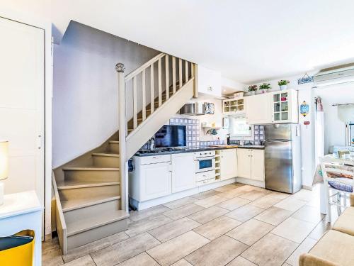 a kitchen with white cabinets and a staircase at Holiday Home Les Parcs de Gassin-1 by Interhome in Saint-Tropez