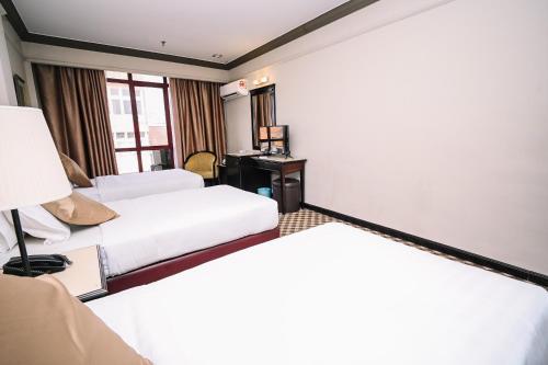 a hotel room with two beds and a desk at Kingston Hotel 9 - Jonker Street Malacca in Kampong Morten