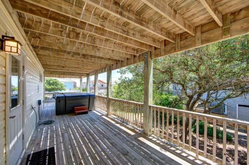 a wooden deck with a table on a house at Porch Song in Kitty Hawk