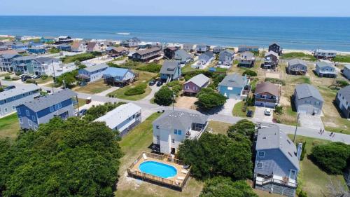 an aerial view of a neighborhood with houses and the ocean at Porch Song in Kitty Hawk
