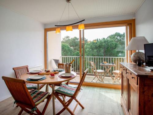 une salle à manger avec une table et des chaises et un balcon dans l'établissement Apartment L'Ermitage-3 by Interhome, à Saint-Brévin-les-Pins