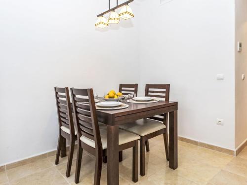 a dining room table with four chairs and a bowl of fruit at Holiday Home Llevant by Interhome in Creixell