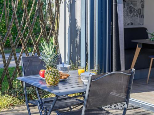une table bleue avec un ananas et des fruits dessus dans l'établissement Apartment Otello 3 - L'Ibis rouge by Interhome, à Carnac