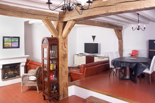 a living room with a table and a dining room at Gite Place De La Fontaine in Hautvillers