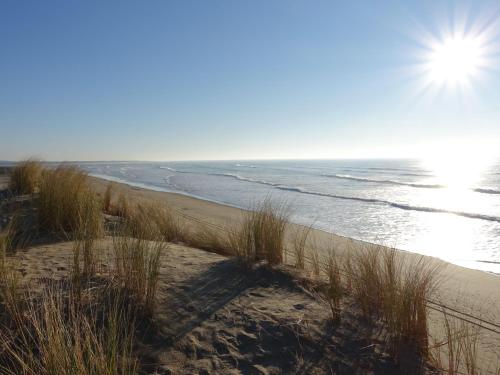 a sandy beach with the ocean and the sun at Holiday Home La Langrotte by Interhome in Dolus-d'Oléron