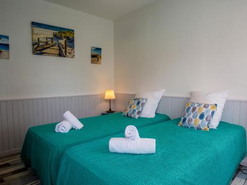 - une chambre avec 2 serviettes sur un lit vert dans l'établissement Holiday Home Le Plan d'Eau-2 by Interhome, à La Bernerie-en-Retz