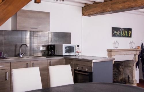 a kitchen with a table and chairs and a microwave at Gite Place De La Fontaine in Hautvillers