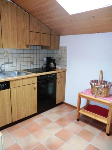 a kitchen with wooden cabinets and a black dishwasher at Sonja in Schwarzsee