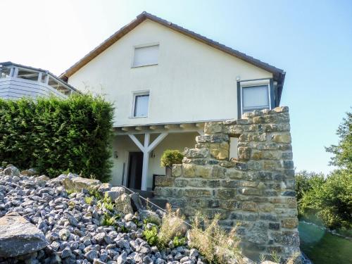 a house with a stone wall in front of it at Apartment Am Waldrand by Interhome in Lügde