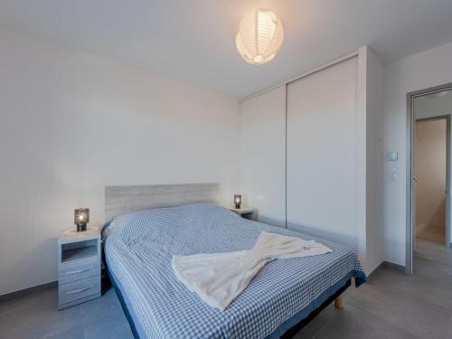 a white bedroom with a bed and a night stand at Apartment Collioure le haut-1 by Interhome in Collioure