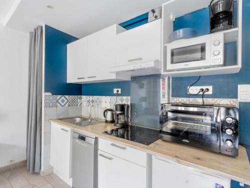 une cuisine avec des armoires blanches et un micro-ondes dans l'établissement Apartment T2 Lambert by Interhome, à Toulon