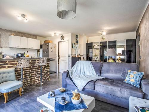 un salon avec un canapé bleu et une cuisine dans l'établissement Studio Les Terres Marines by Interhome, à Saint-Laurent-du-Var