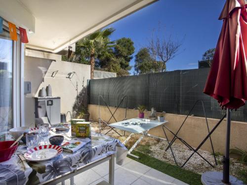 un patio avec une table et un parasol dans l'établissement Studio Les Terres Marines by Interhome, à Saint-Laurent-du-Var