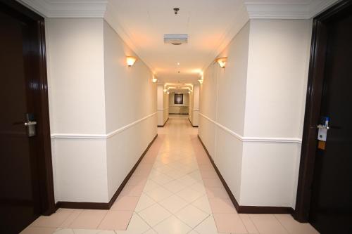 a hallway in a building with white walls and a tile floor at Kingston Hotel 9 - Jonker Street Malacca in Kampong Morten