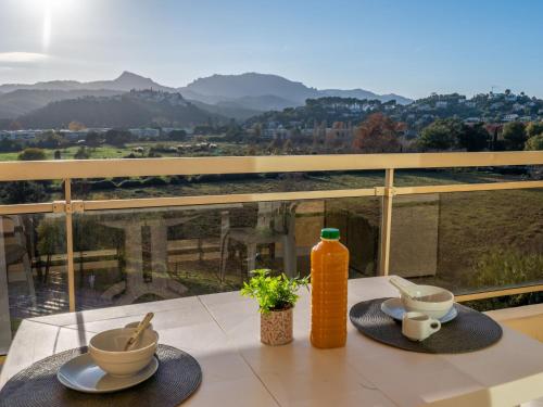 - une table avec deux plats et une bouteille de jus d'orange dans l'établissement Apartment Résidence des Golfeurs by Interhome, à Mandelieu-la-Napoule