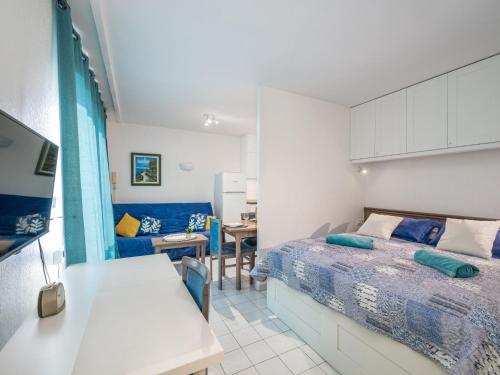 une petite chambre avec un lit et un canapé dans l'établissement Apartment Résidence des Golfeurs by Interhome, à Mandelieu-la-Napoule