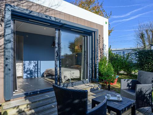 d'une terrasse avec des portes en verre, une table et des chaises. dans l'établissement Apartment Otello 1 - L'Ibis Noir by Interhome, à Carnac