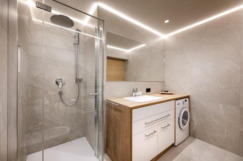 a bathroom with a shower and a washing machine at Apartment Fina in Ortisei