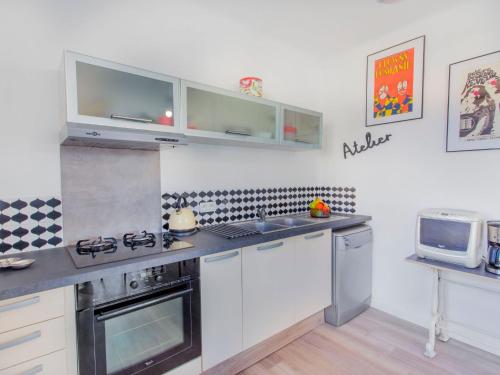 une cuisine avec des armoires blanches et un four à plaques de cuisson dans l'établissement Apartment Phichris by Interhome, à Hyères