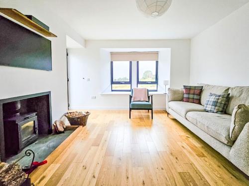a living room with a couch and a fireplace at Holiday Home Carbost Cottage by Interhome in Tole