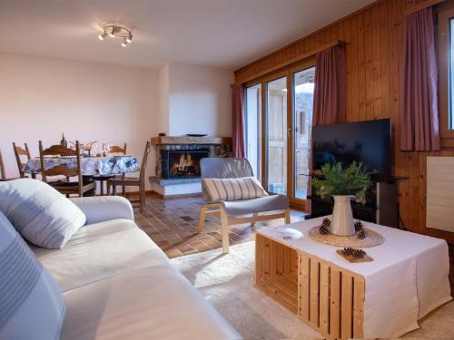 ein Wohnzimmer mit einem weißen Sofa und einem Fernseher in der Unterkunft Apartment Le Schuss 1 by Interhome in Gryon