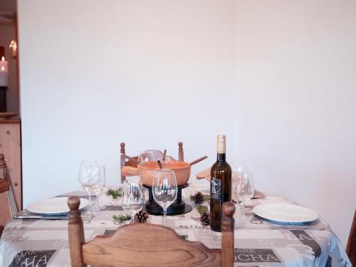 einen Tisch mit einer Flasche Wein und Weingläsern in der Unterkunft Apartment Le Schuss 1 by Interhome in Gryon